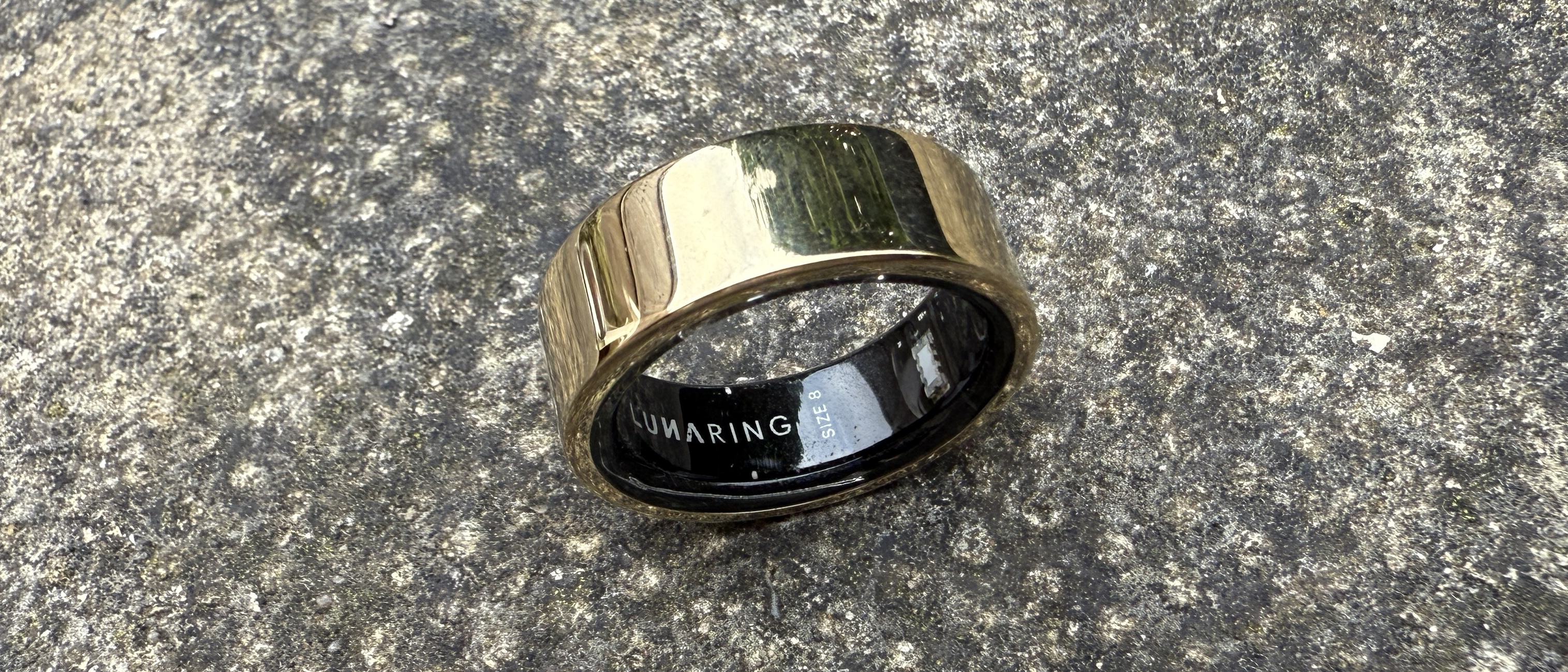 The Luna Ring 2 in Sunlit Gold on a concrete surface