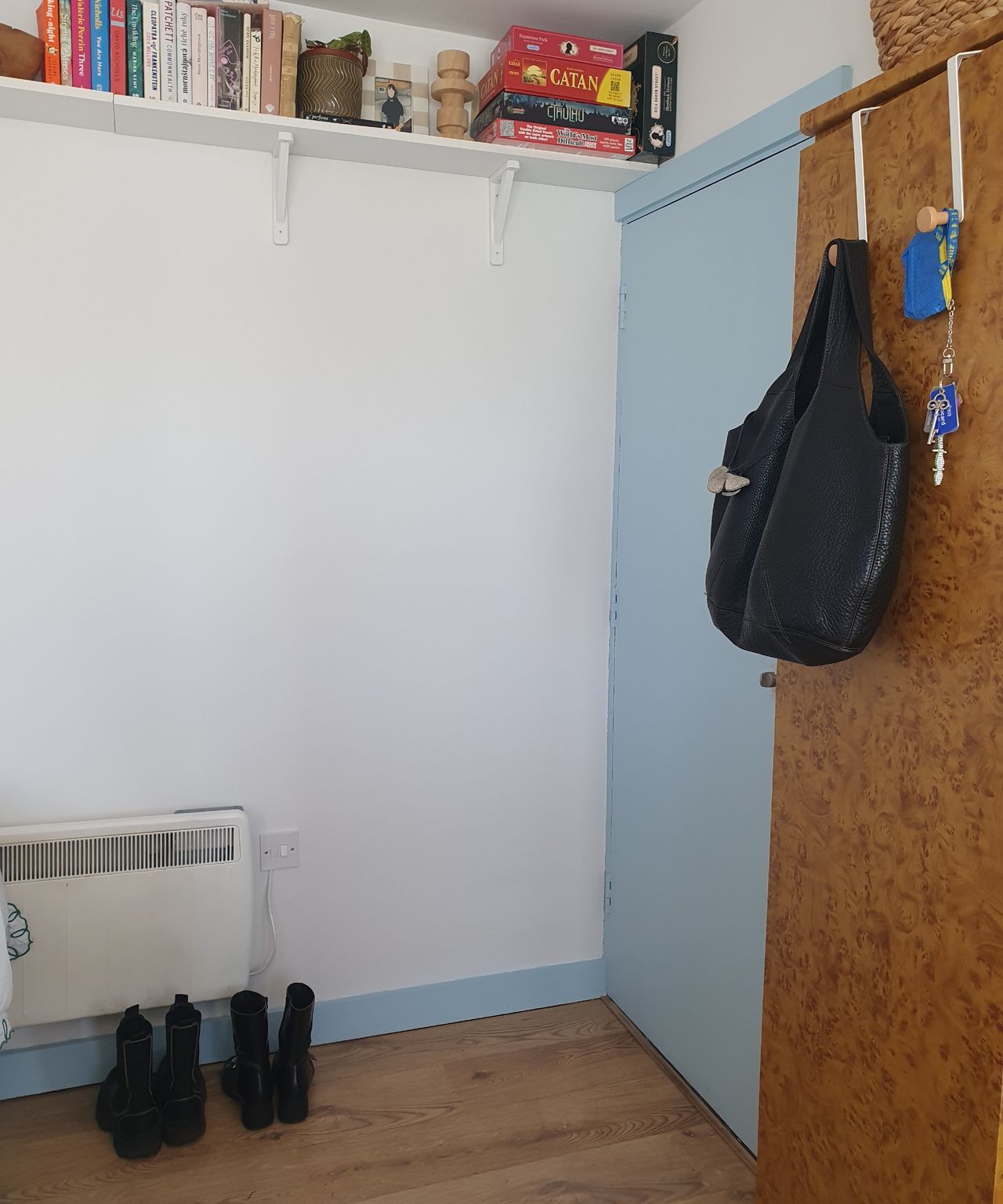 Before: Sara's entrance area with two pairs of shoe out, keys hanging on a hook on the wardrobe door and a bare wall
