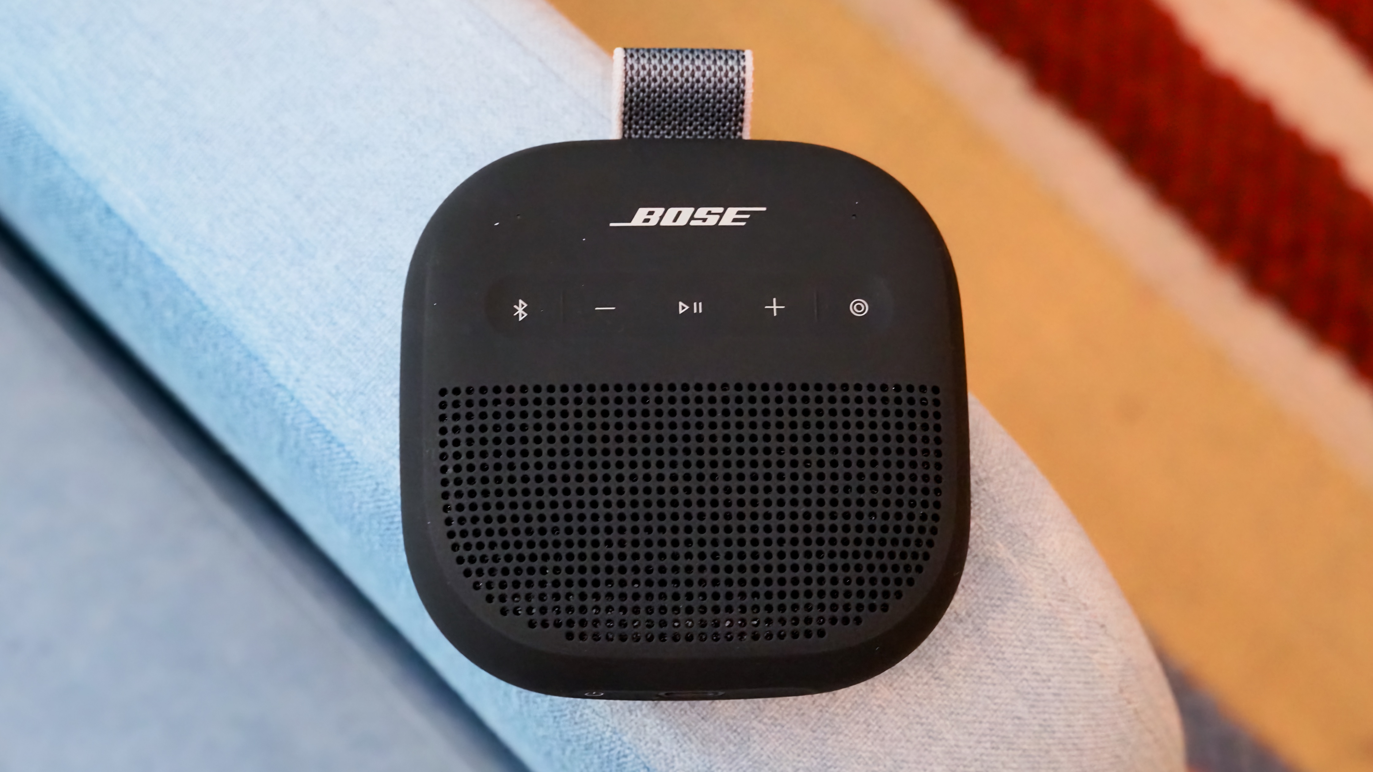 The Bose SoundLink Micro 2 in black on a blue chair. 
