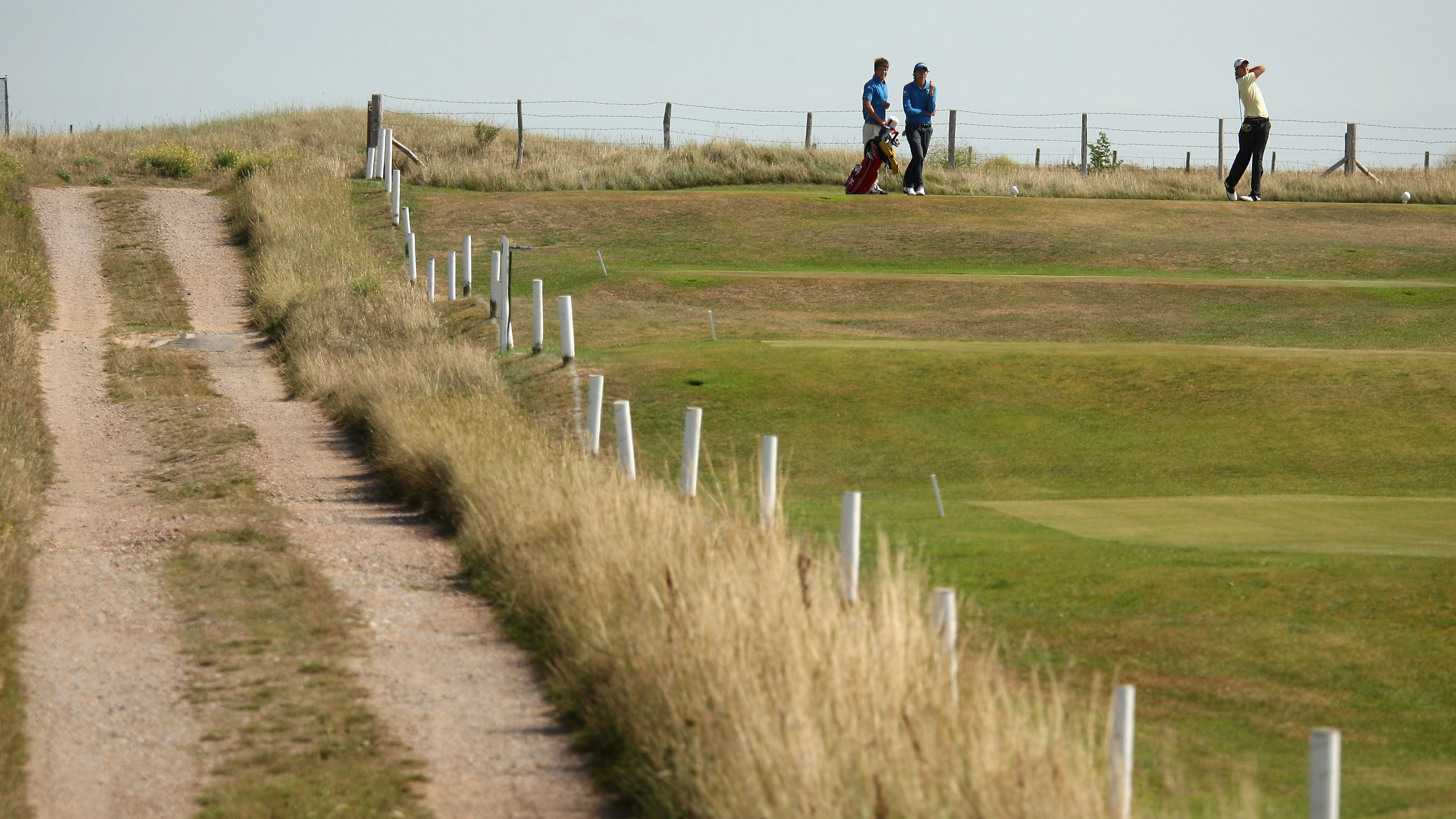 players driving from a tee with out of bounds to the right