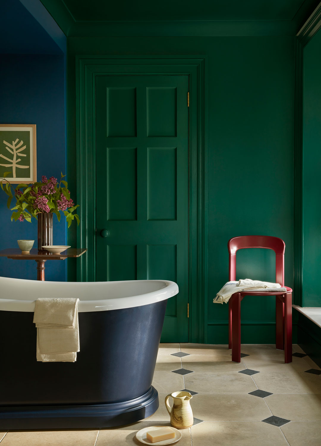 bathroom with blue and green walls and deep blue freestanding bath