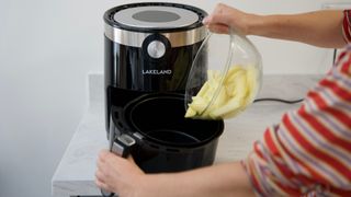 Adding potatoes to an airfryer