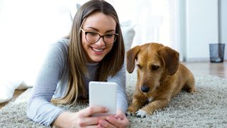 Lady and dog looking at mobile phone