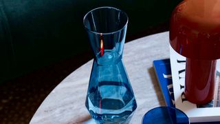 a blue shapely glass vase on a white table