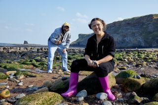 Joe Wilkinson and Rosie Jones pose on the rocky beach at Whitby while hunting for fossils