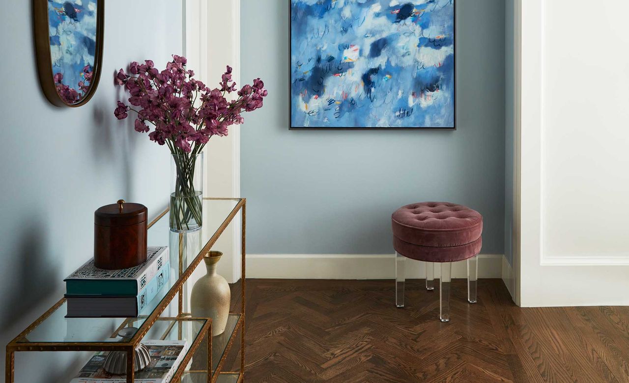 a blue entryway with stools and flowers