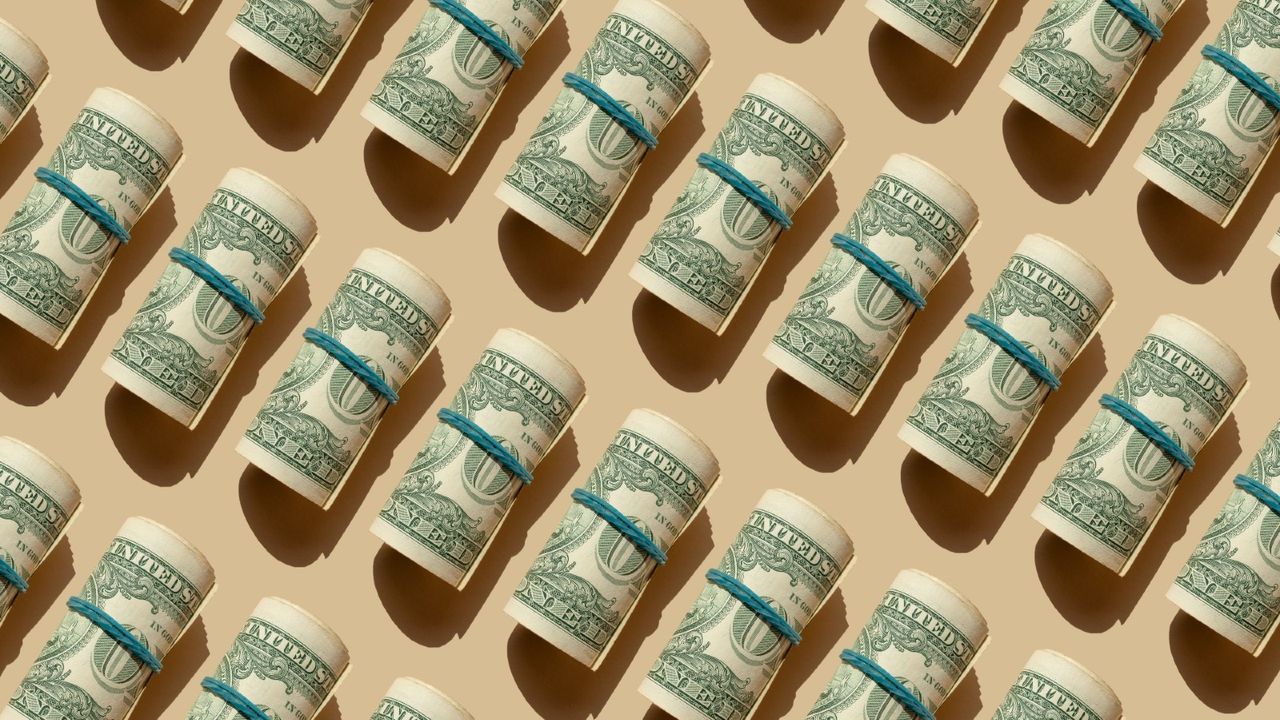 rolls of dollars on beige background