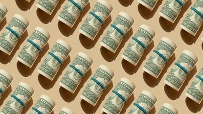 rolls of dollars on beige background