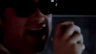 Kurt Russell wearing sunglasses and yelling into a CB radio in Big Trouble In Little China