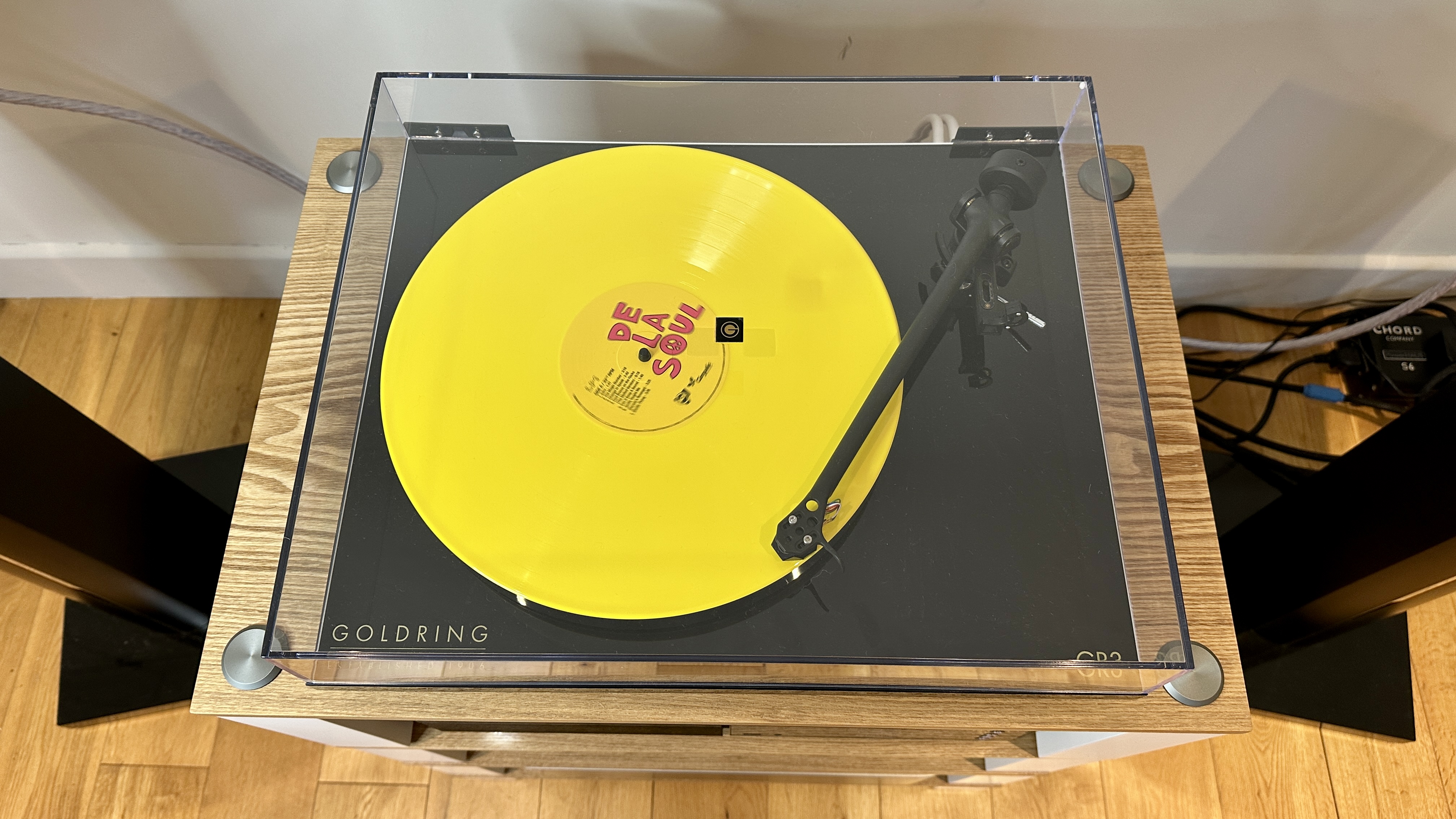 Goldring GR3 turntable, with the dust cover closed, with a yellow De La Soul record on the platter.
