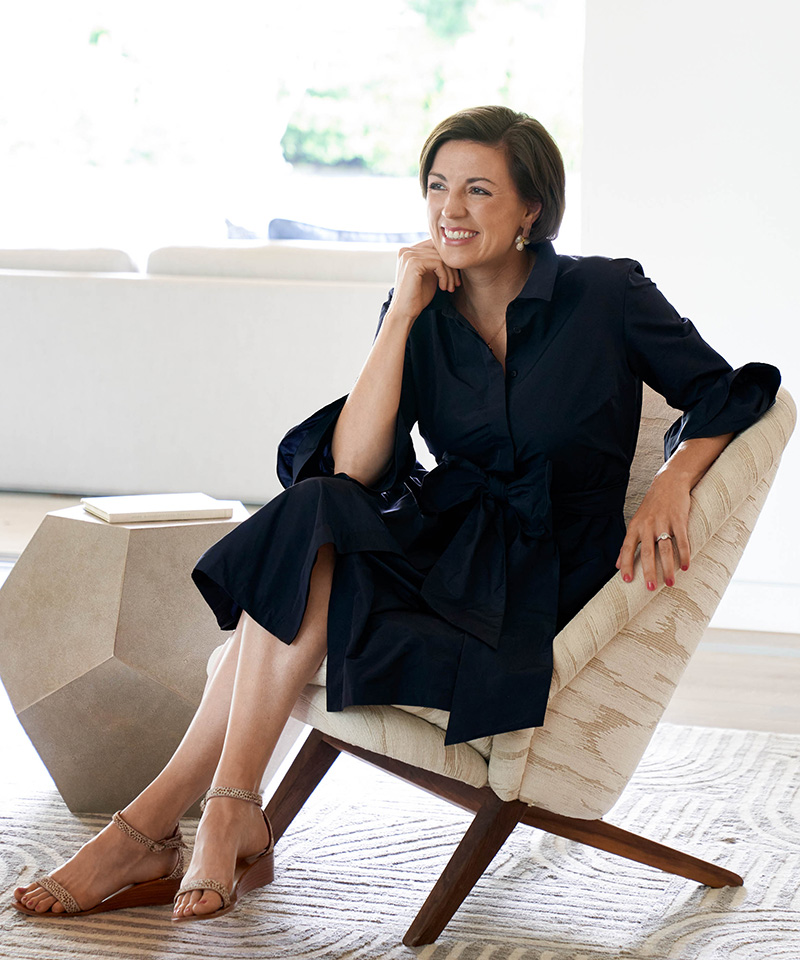 a woman in a blue dress sitting in a chair