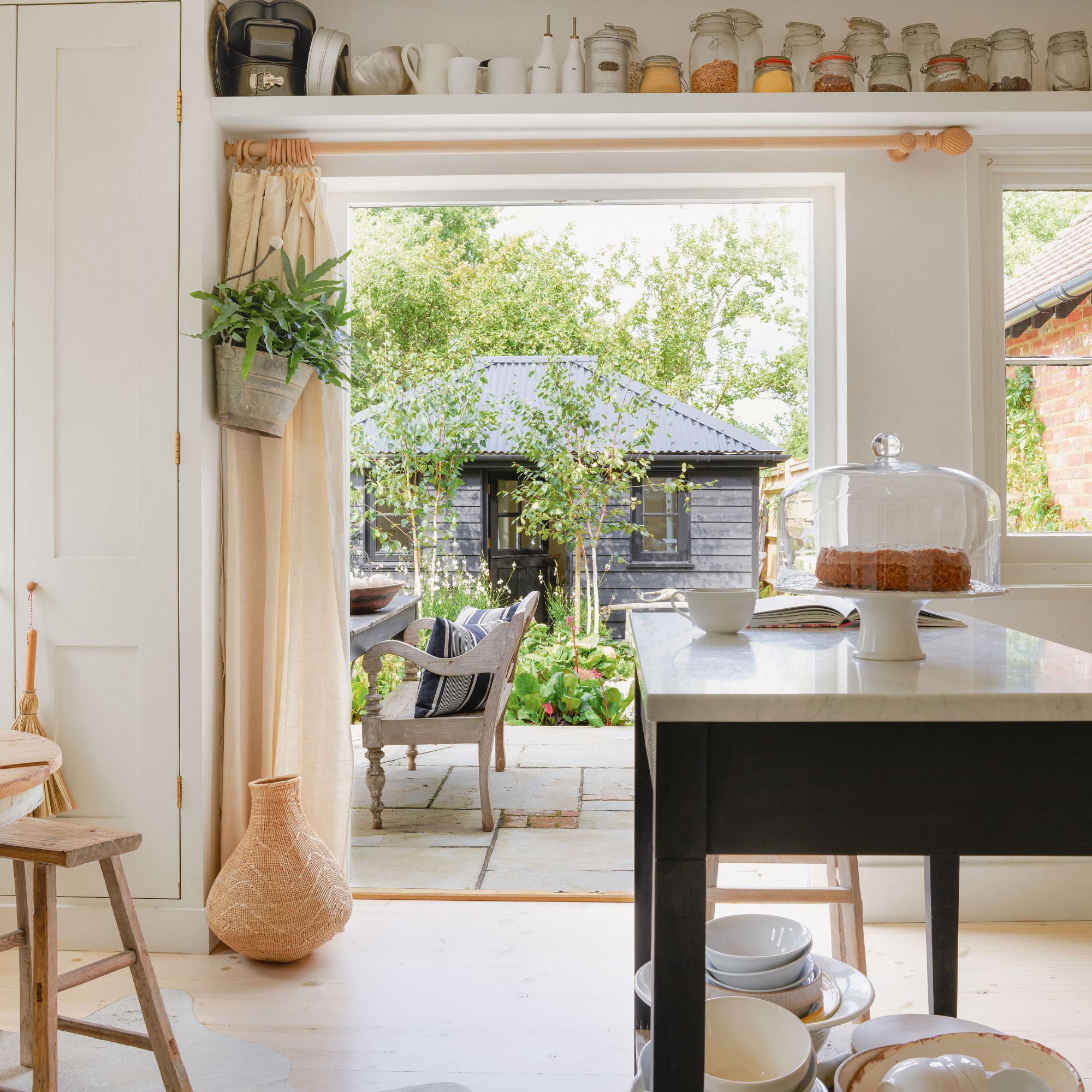country kitchen with farmhouse-style island and view to garden through french doors