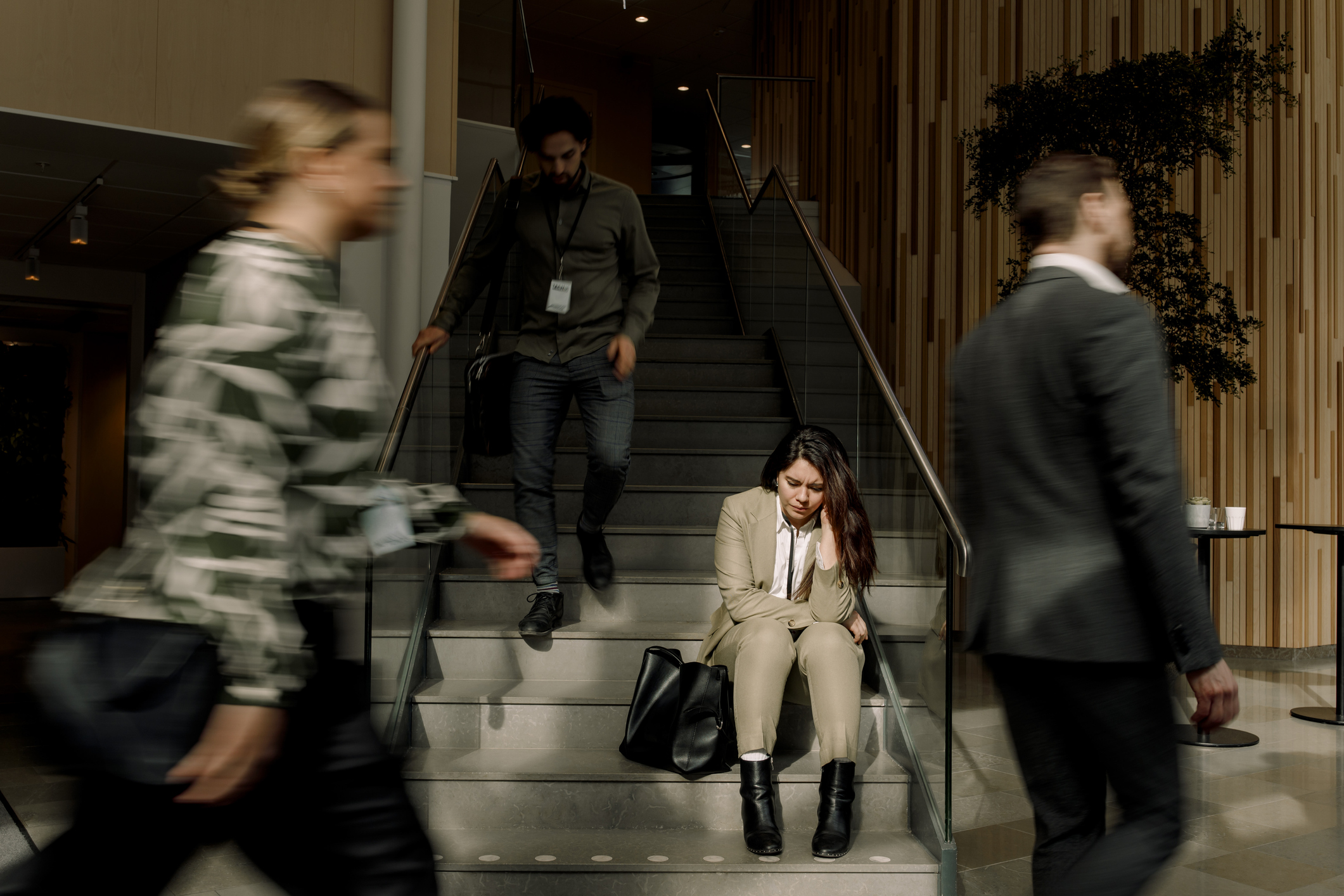 Frustrated businesswoman sitting on staircase at convention centre