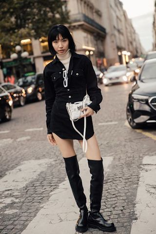 woman wearing black mini dress, beige turtleneck, and black thigh-high boots