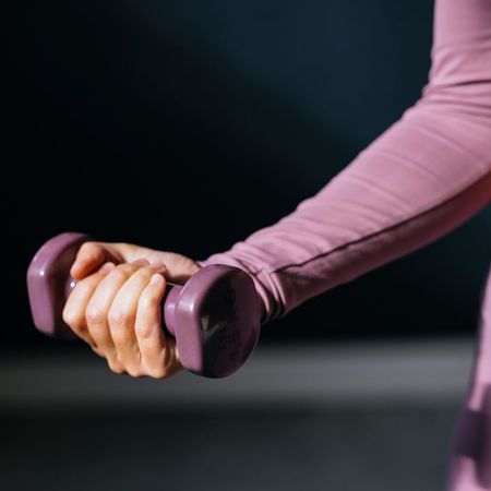 A woman doing a bicep curl at the gym