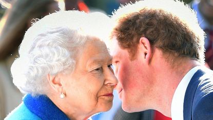 Queen Elizabeth smiles as Prince Harry leans in towards her.