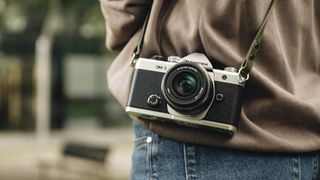 OM System OM-3 mirrorless camera slung over the shoulder