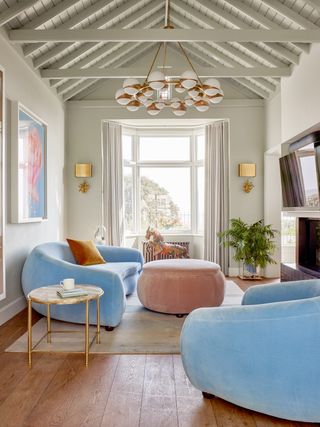 Neutral living room with blue sofas and pink pouff