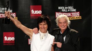 Jimmy Page (right) and Jeff Beck holding aloft his trophy after being inducted into the Rock and Roll Hall of Fame in 2009