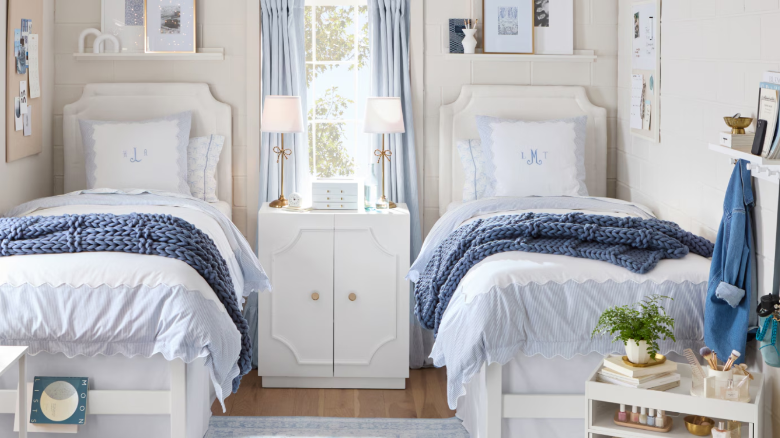 a dorm room with two matching twin beds with a blue color scheme and light tan walls