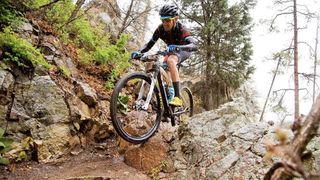A mountain biker riding through a tough rocky section