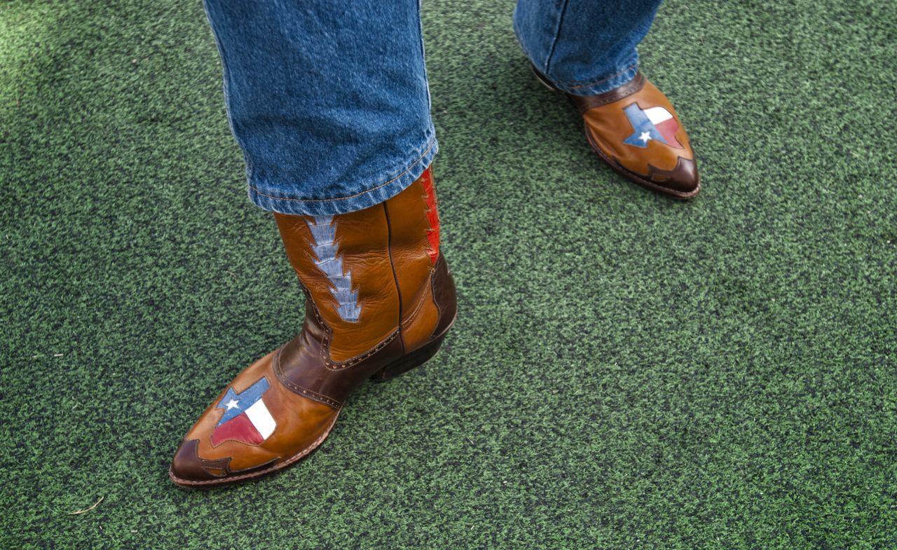 Cowboy boots stepping on grass