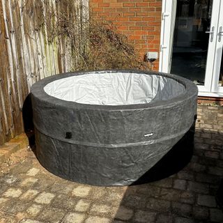 The faux-leather effect Wave Osaka hot tub empty on a paved patio