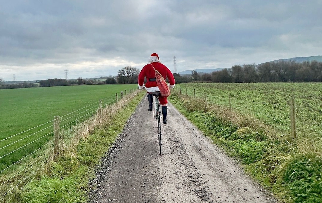 Charlie Burrell on a penny-farthing in a Santa costume