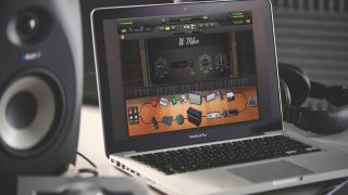 A MacBook in a studio with Amplitube 5 guitar plugin on screen