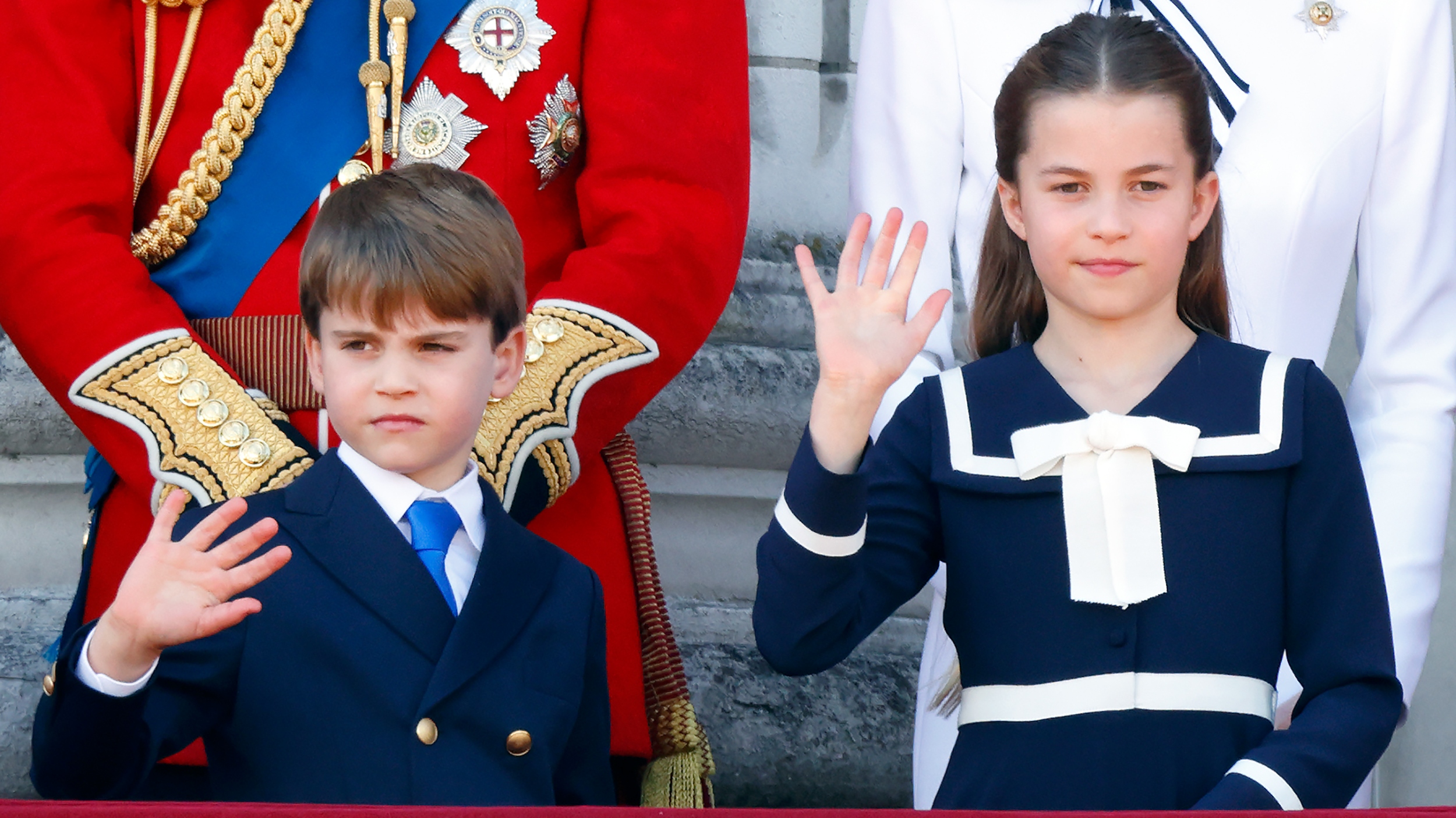 Prince Louis of Wales and Princess Charlotte of Wales wave as they watch an RAF flypast