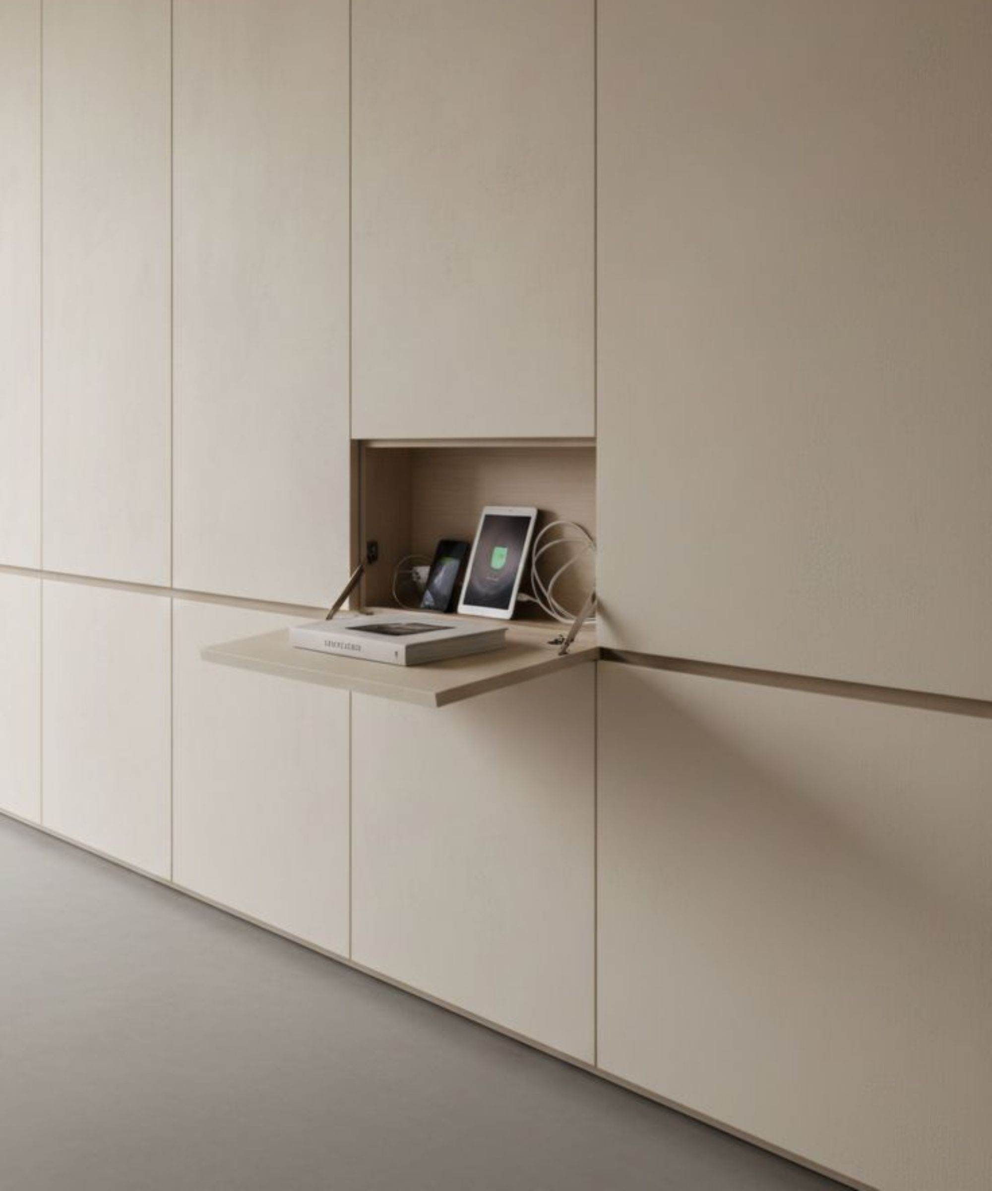 Cream cupboards with opening, showing a book, ipad and wires