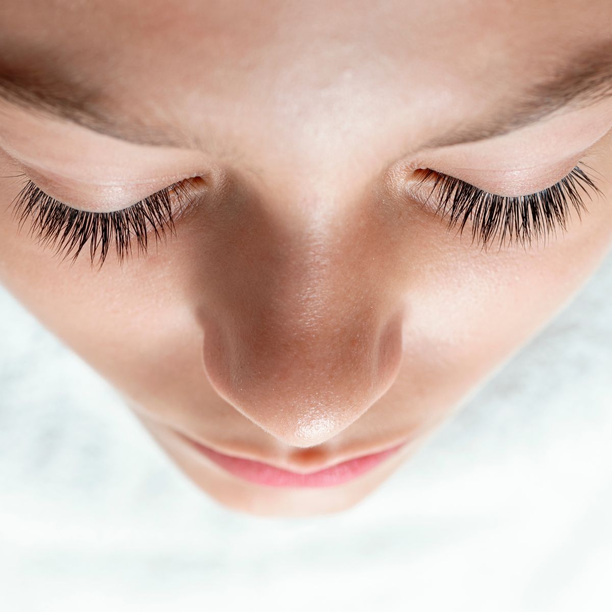 A woman&#039;s face shot from above showing beautiful long lashes