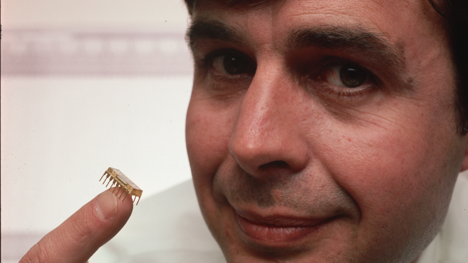 Ward Parkinson, an engineer who founded Micron Technology, Inc. with his twin brother Joe, holds a silicon flake containing 64K of RAM. Micron is a manufacturer of innovative memory chips.