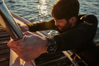 A man climbing out of the water while wearing the OnePlus Watch 2.