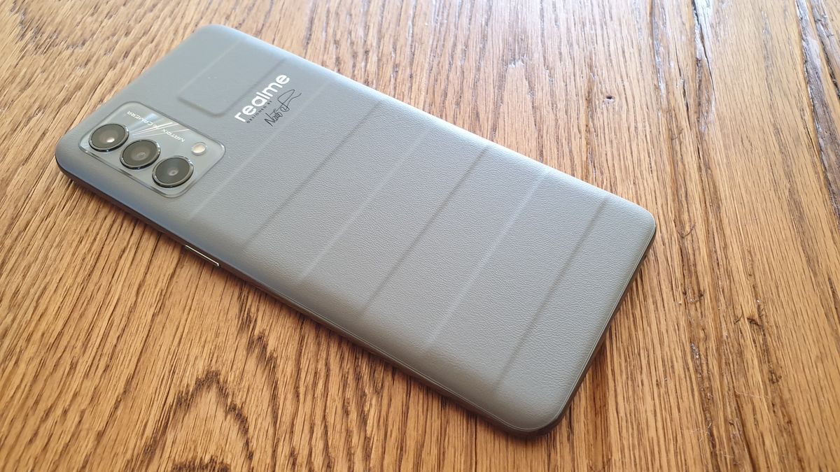 Das Realme GT Master Edition mit dem Gesicht auf einem Holztisch liegend.
