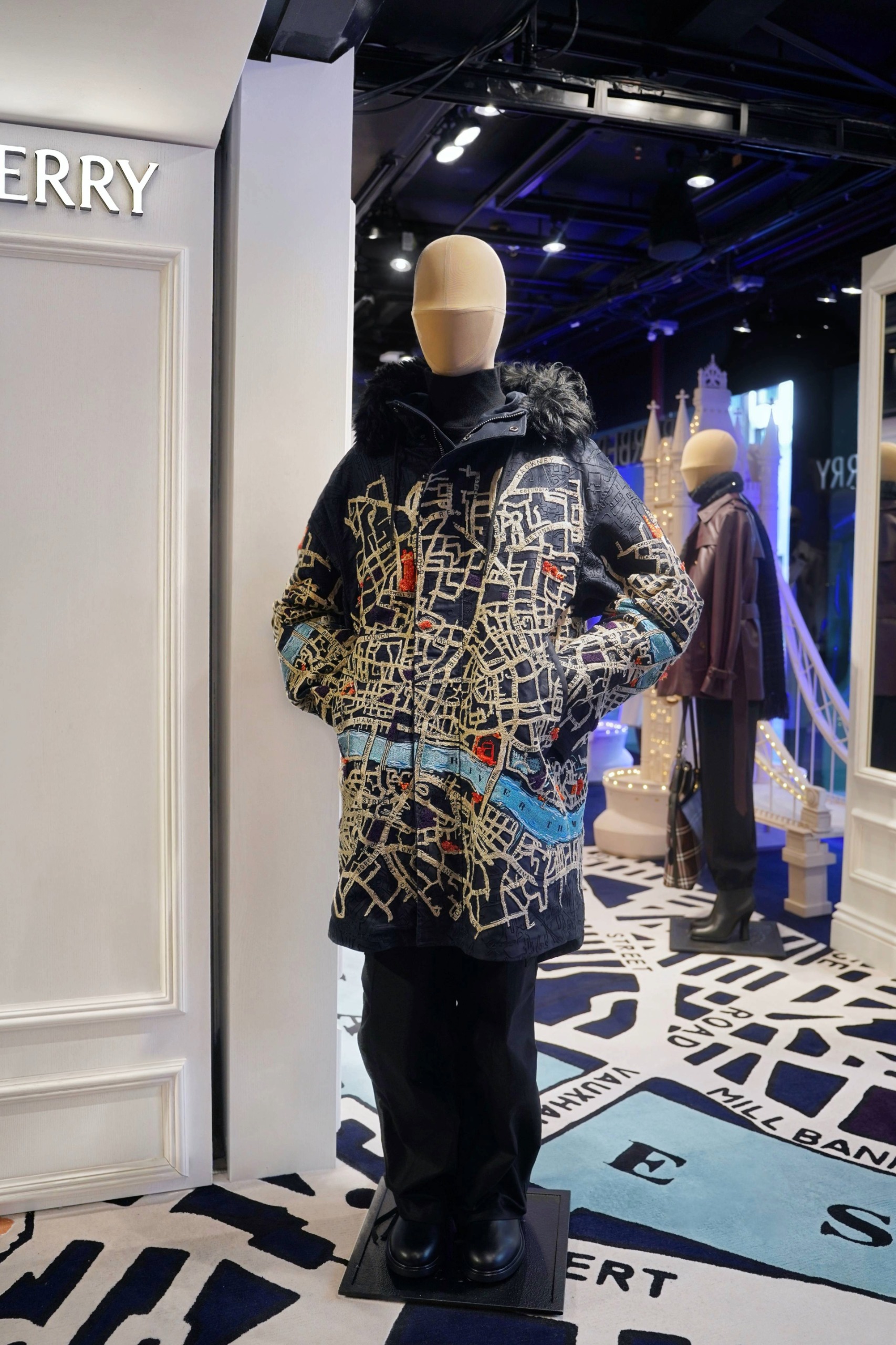A pop-up space inside Harrods selling Burberry products. It's decorated with a London map-design wallpaper and carpet