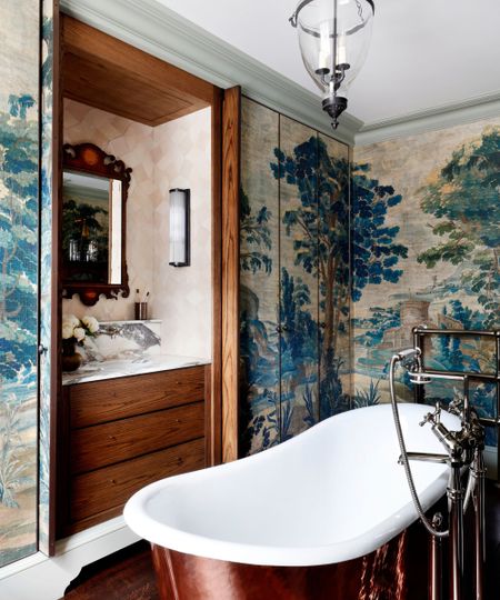 A broken plan bathroom with a freestanding bathtub and a vanity hidden behind pocket doors