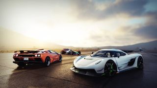 The Crew 2 screenshot showing three cars parked on an open road