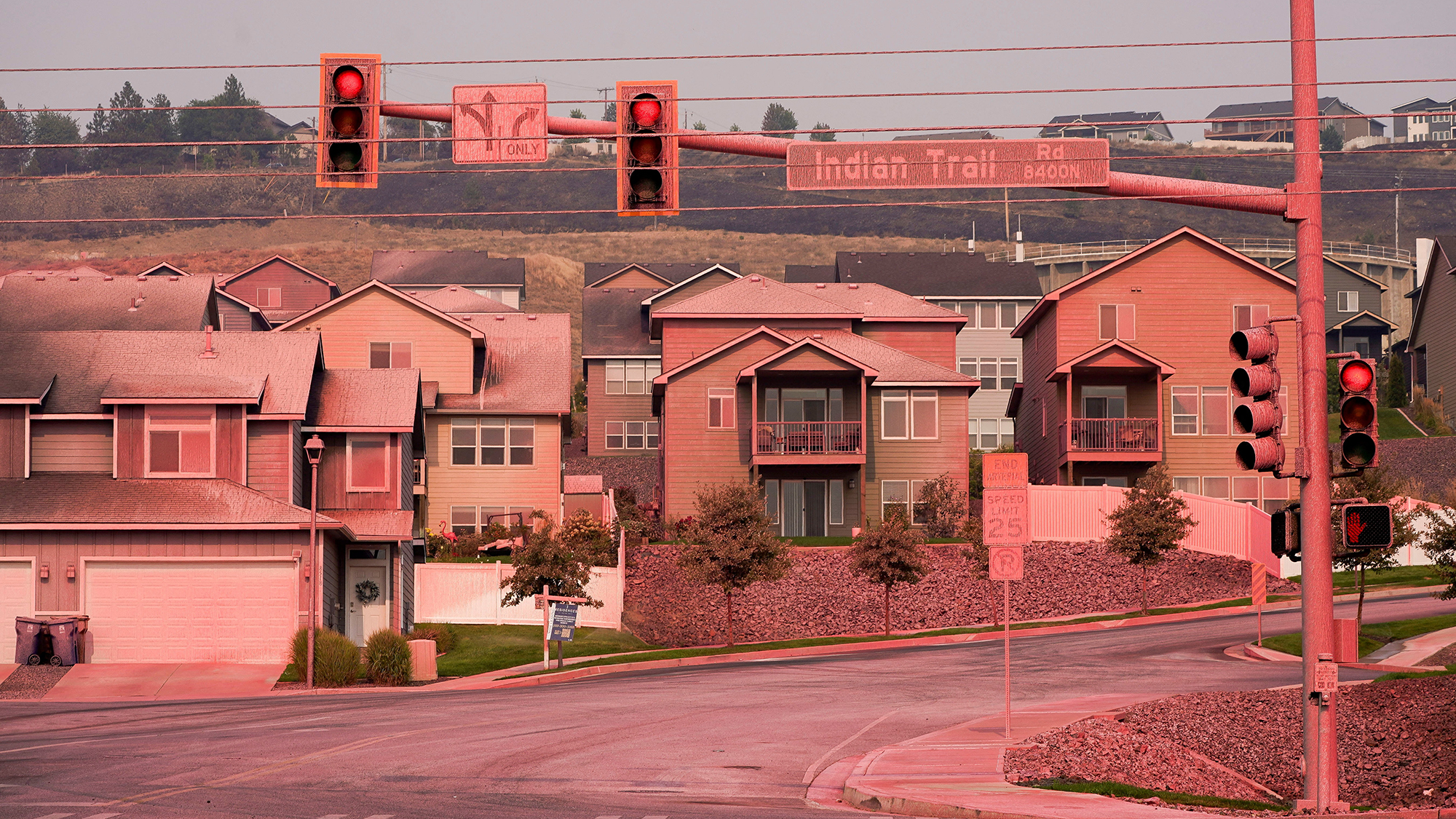 Homes are colored pink after being coated with fire retardant chemicals in in Spokane, Washington