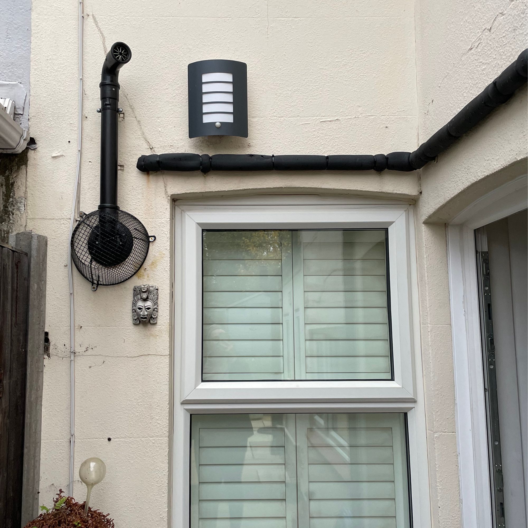 Boiler flue and pipes on the back of a terraced house