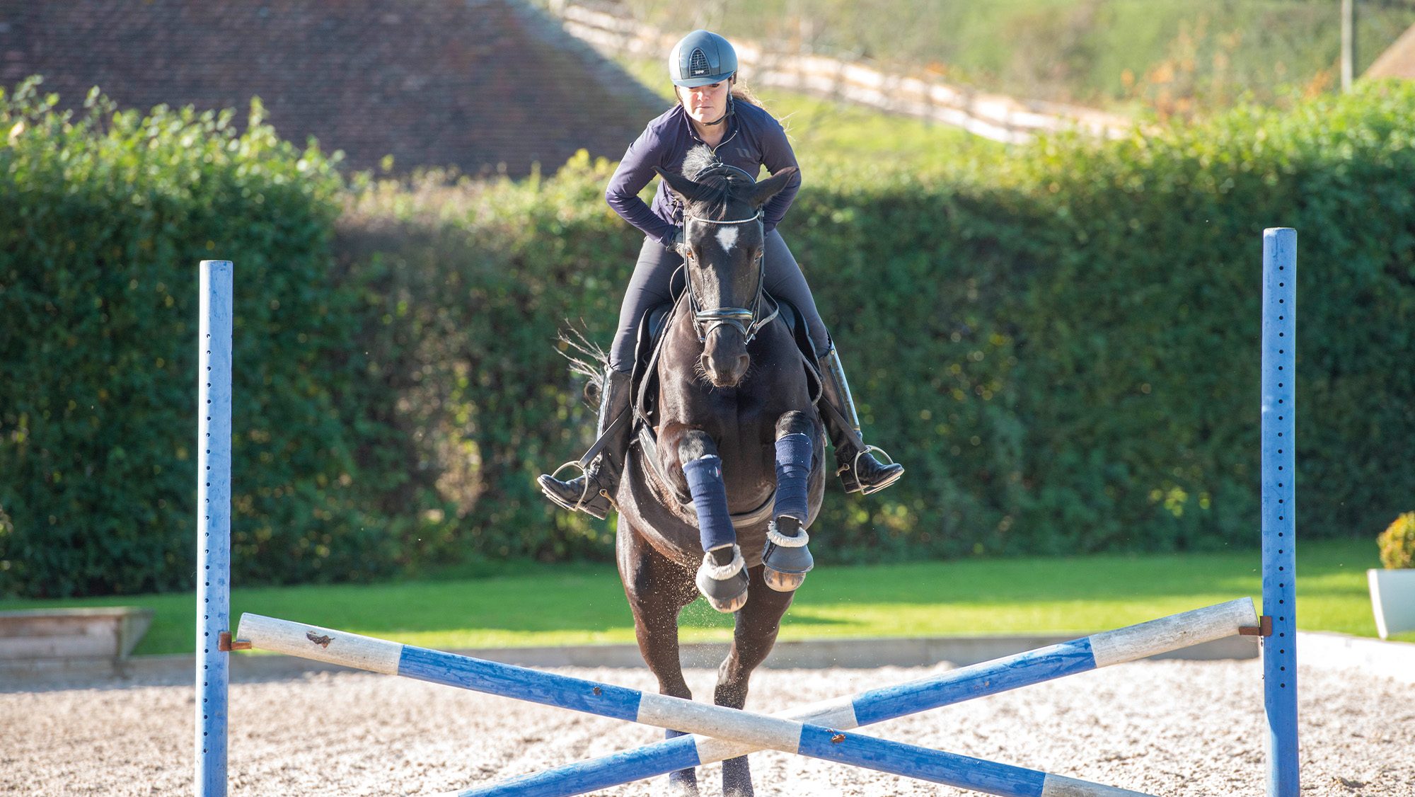 Rider jumping cross pole towards camera