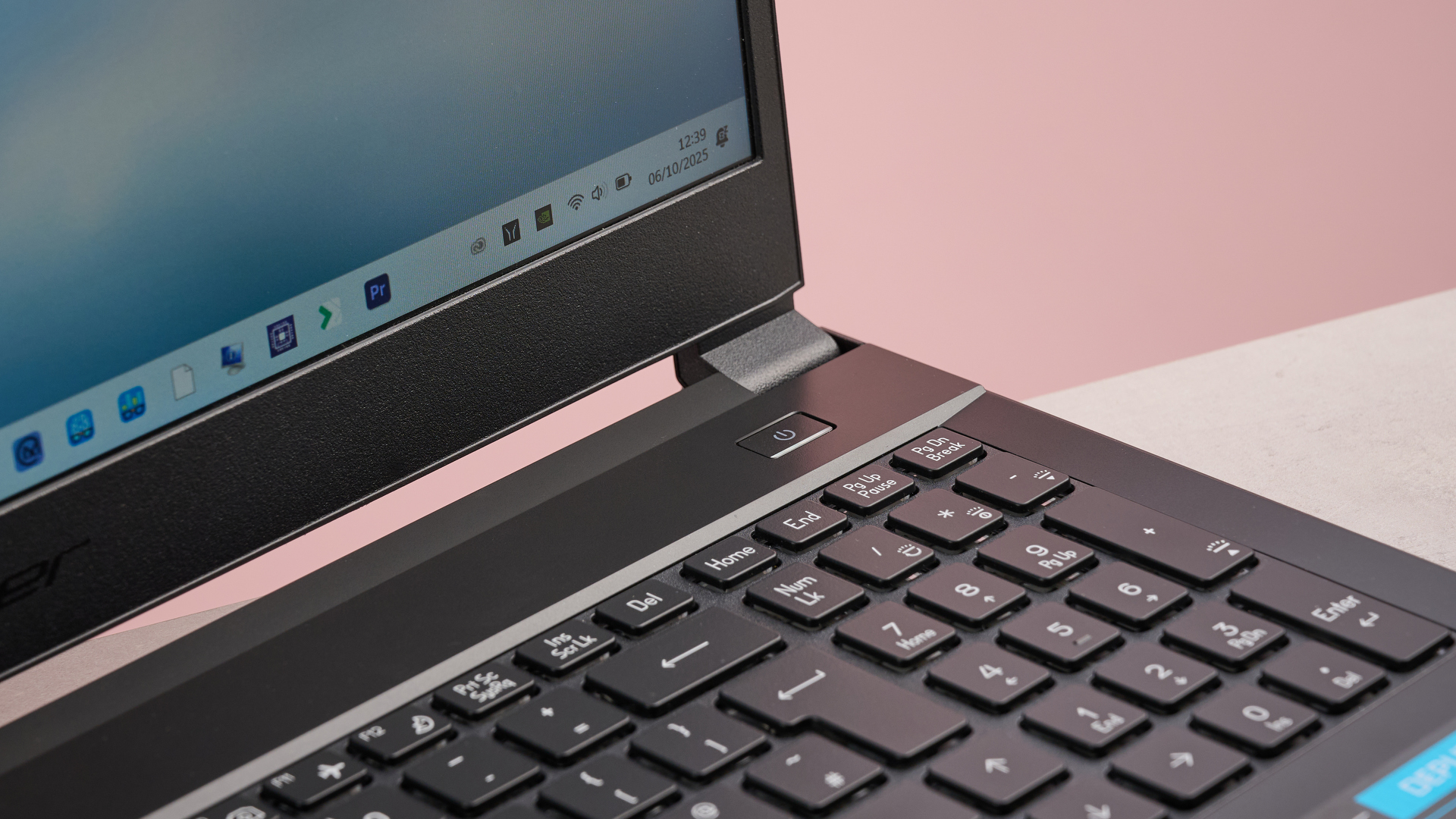 Close-up of right lid hinge on Medion Erazer Deputy 15 P1, open on desk with green wall in background