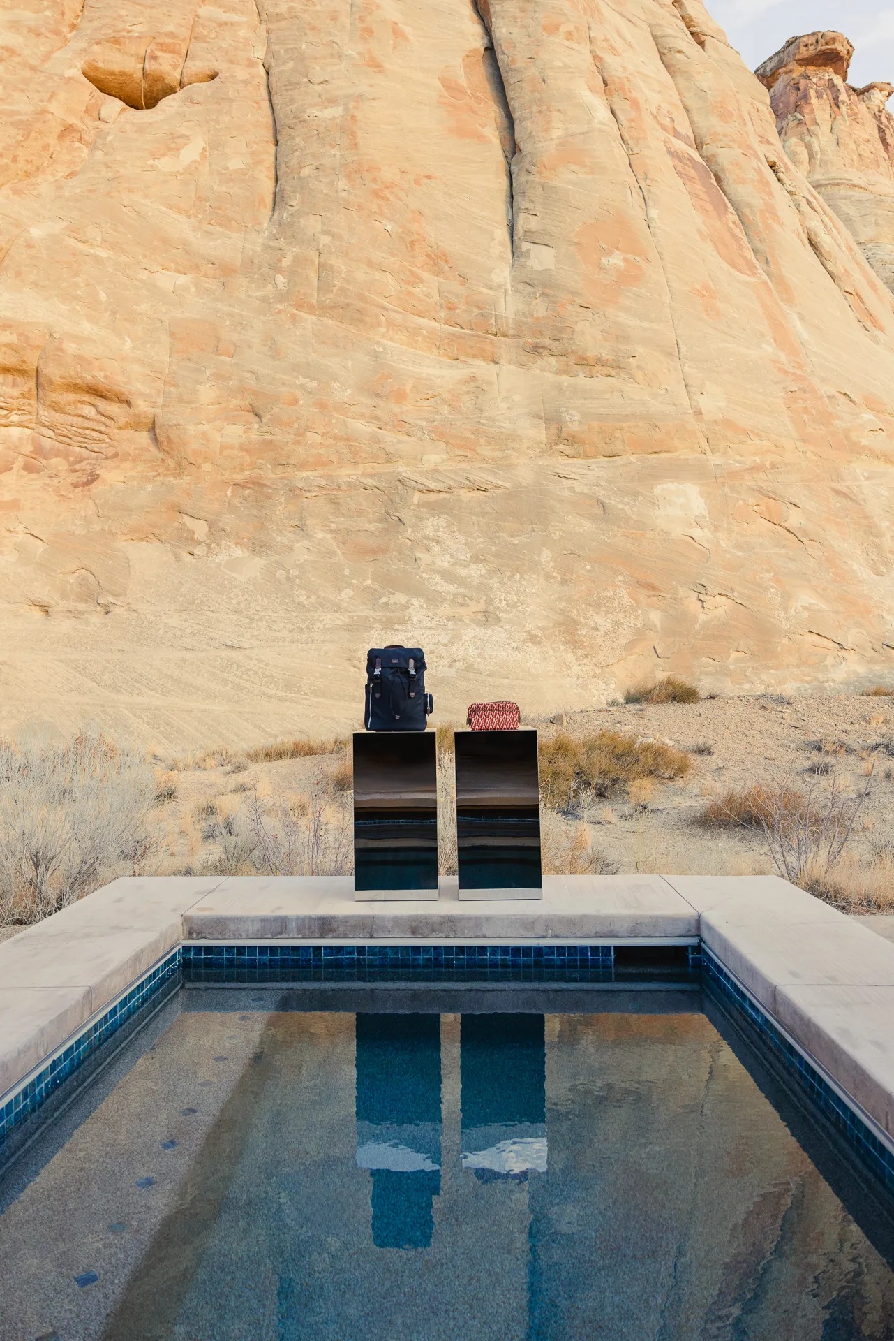 The offering of a sleek hotel gift shop is set up among the dramatic mountain range of Utah's desert, nestled either within a camel tent decorated with sophisticated, reflective furniture, or en-plain-air in dialogue with the outdoors.