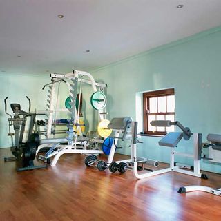 home gym with white wall and wooden floor