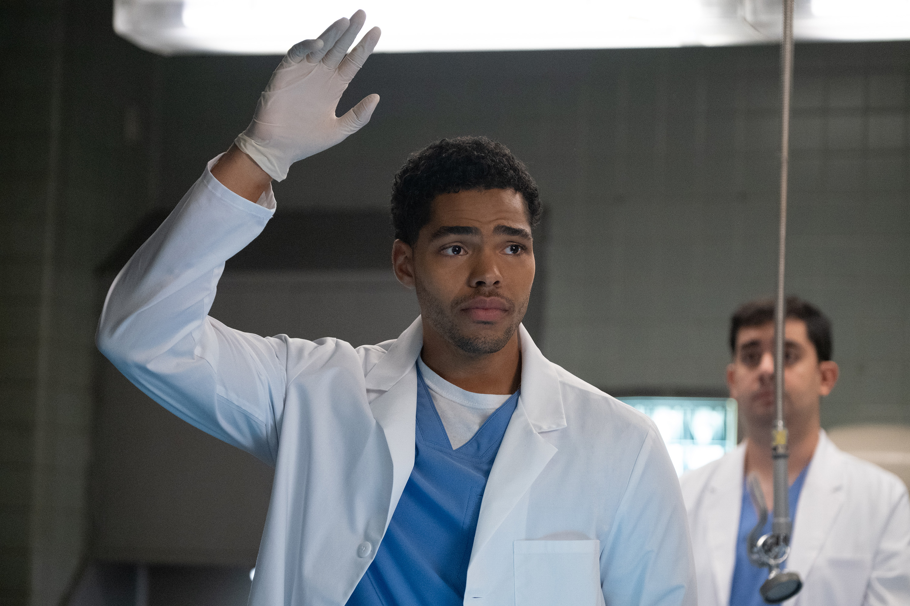 nicholas duvernay as kel wearing a doctor's coat and gloves in a lab in not suitable for work