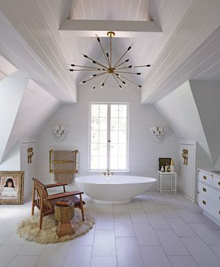 White bathroom with freestanding bath and painted white floorboards