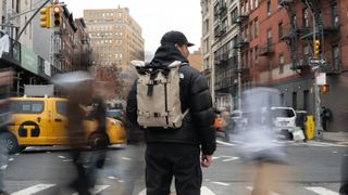 The Wandrd Prvke V4 worn by a photographer on a busy city street