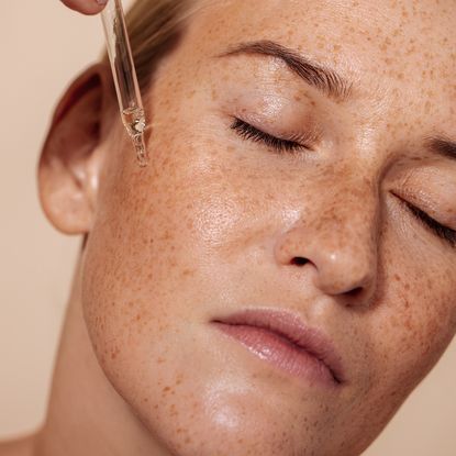 Best serum for pigmentation - woman applying a cream to her skin - getty images 1347067354 