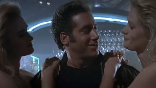 Andrew Dice Clay smiling with a woman on each side of him 