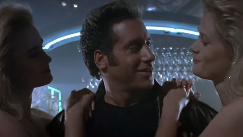 Andrew Dice Clay smiling with a woman on each side of him 